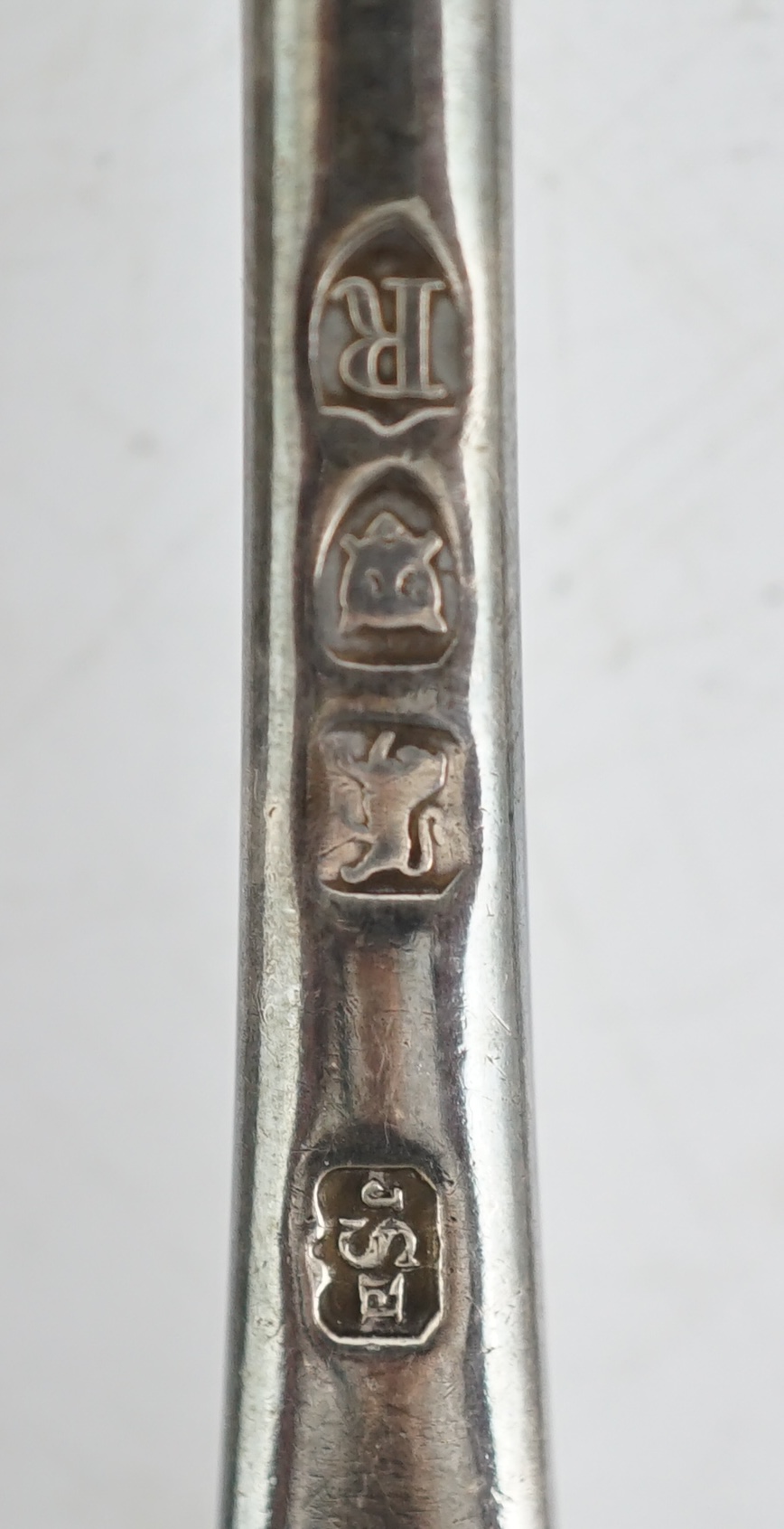 Sundry silver, consisting of three pieces of George III flatware, two 800 standard coffee spoons, a pair of candlesticks(a.f.), a lidded glass preserve pot, clothes brush, two pepperettes and a desk seal.